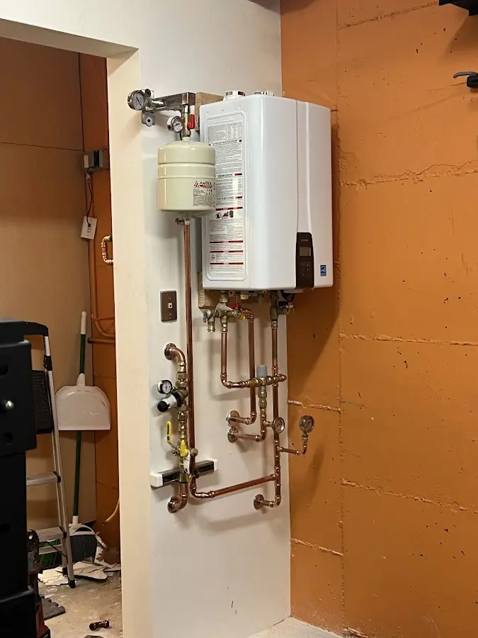 Plumbing technician inspecting water heater connections in New Smyrna Beach